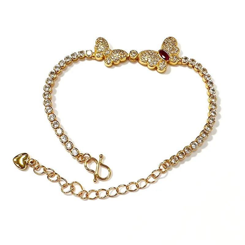 Gold butterfly bracelet with pavé stones and a red marquise stone