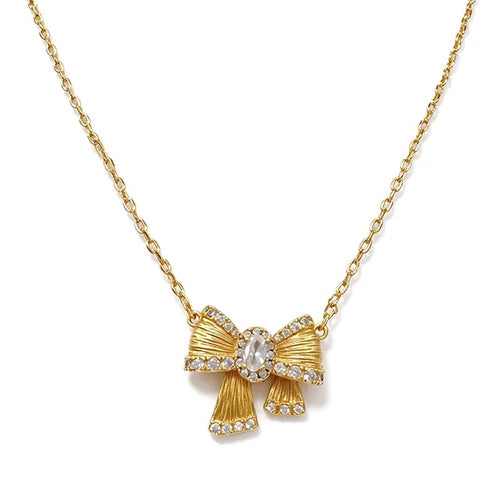 Close-up of the brushed gold bow pendant and its centre stone